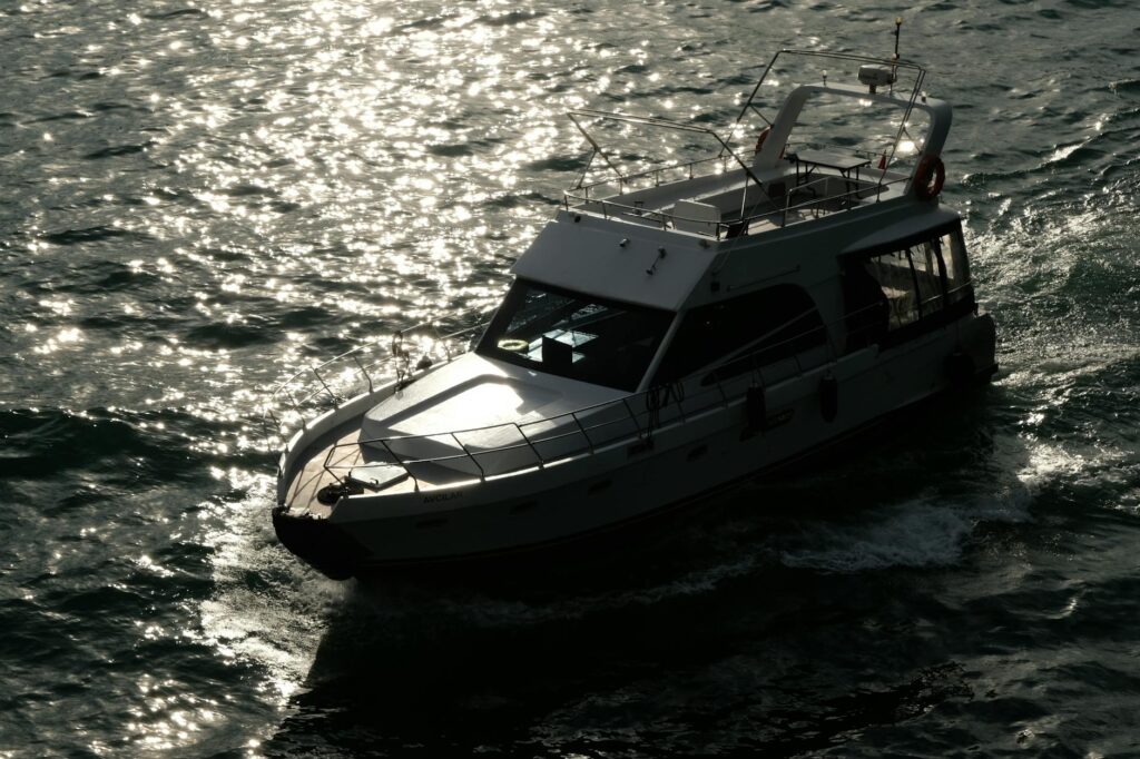A sleek yacht glides effortlessly through sparkling sunlight on open water, creating a serene escape.
