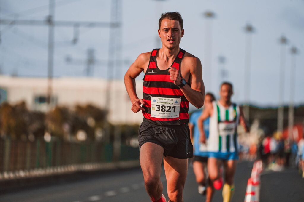 Male runner in a marathon demonstrating focus and determination outdoors.