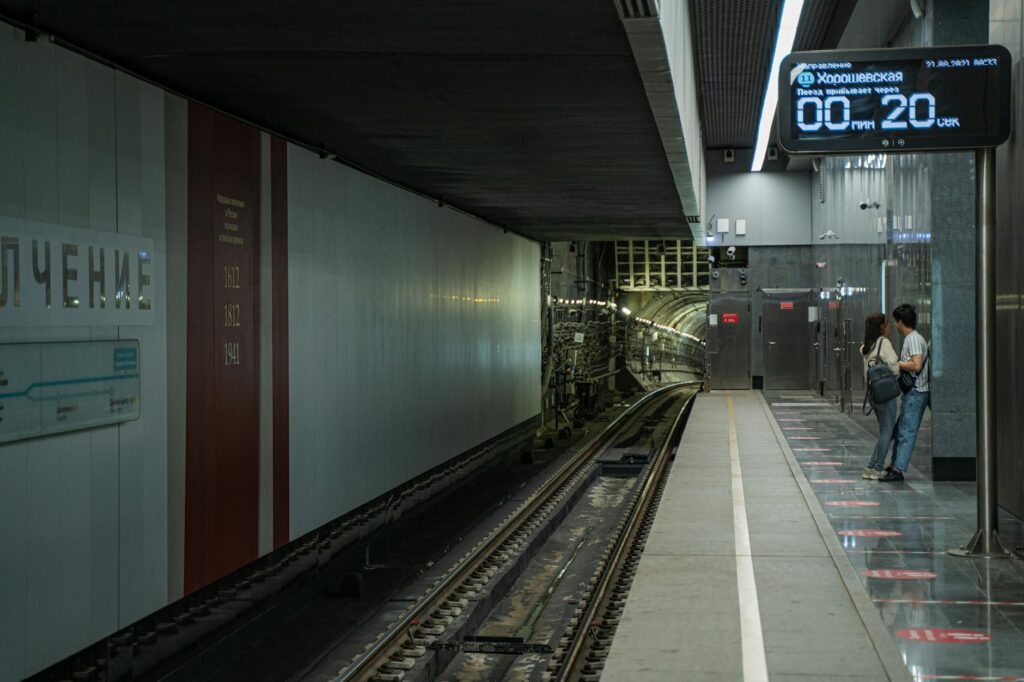 A couple stands on a subway platform, anticipating the next train arrival in Moscow's metro.
