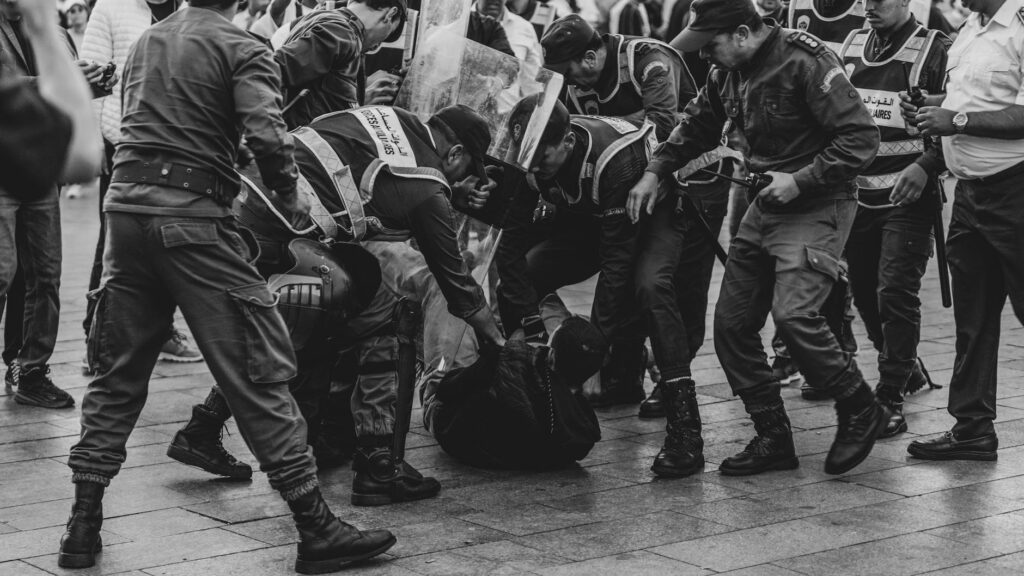 A group of police officers detaining a protester during a demonstration in Rabat, Morocco.