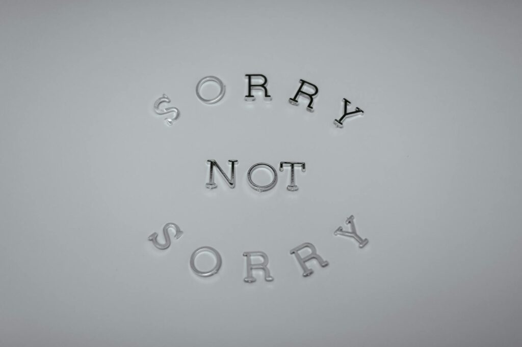 Minimalist design featuring the phrase 'Sorry Not Sorry' arranged in a circular pattern on a white background.