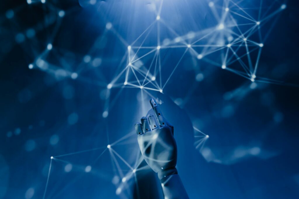 A robotic hand reaching into a digital network on a blue background, symbolizing AI technology.