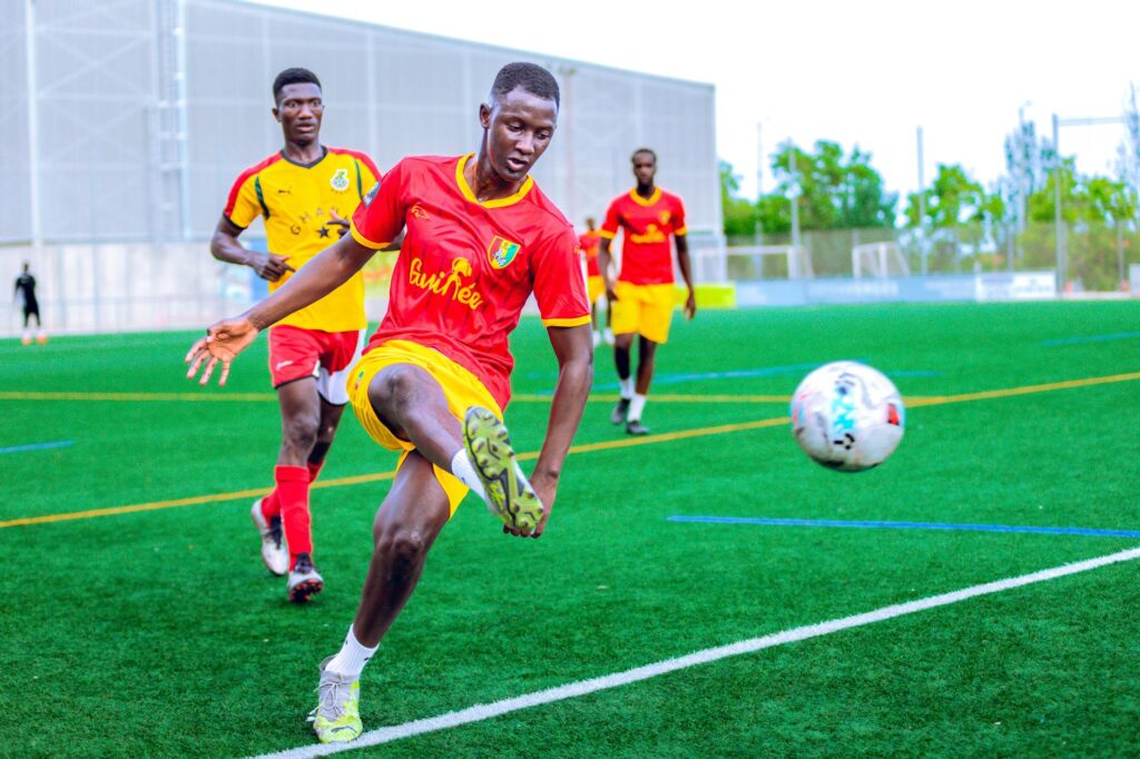 Action-packed soccer match with players in vibrant uniforms on a green field.