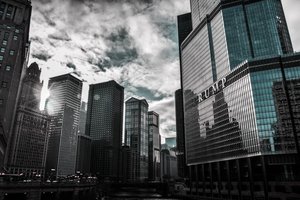 Chicago cityscape featuring Trump Tower with dramatic reflections against a cloudy sky.