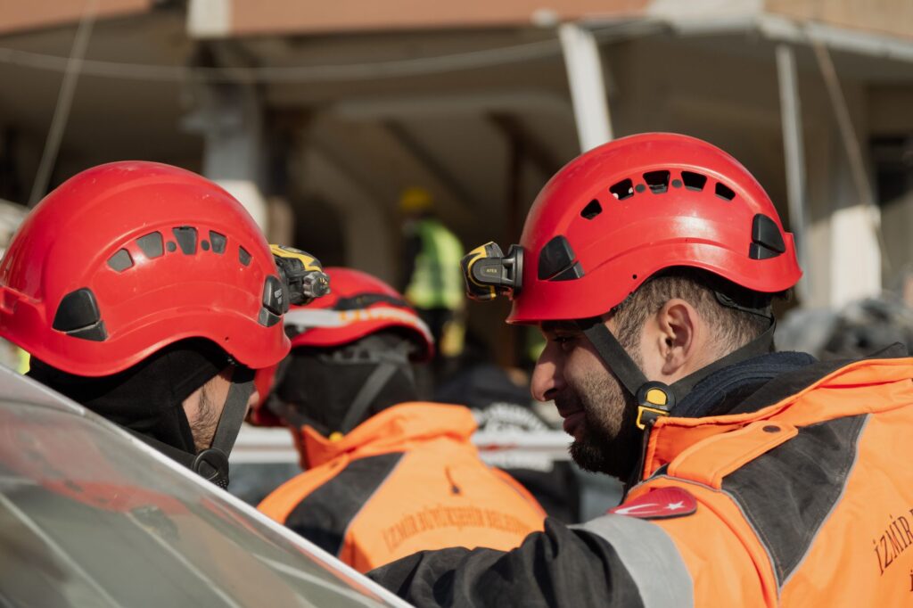 Rescue workers in helmets collaborate during an emergency in Antakya, Türkiye.