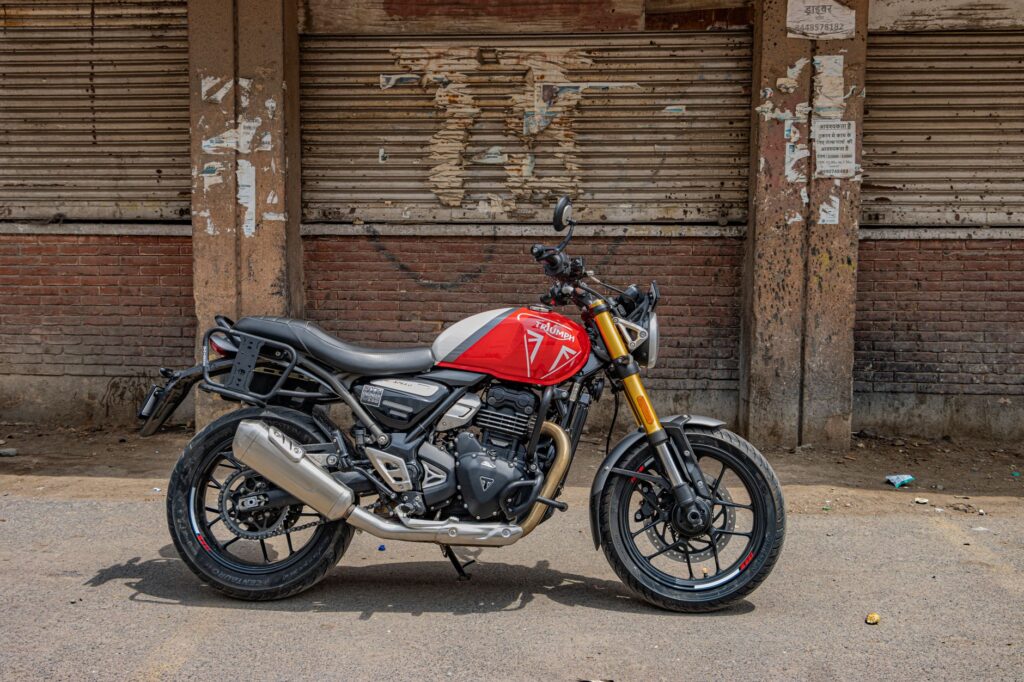 Triumph motorcycle parked outdoors in urban New Delhi, showcasing classic street culture.