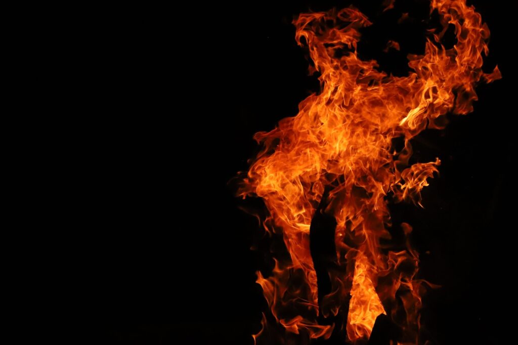 Vivid flames rising in darkness, exuding heat and vibrant energy.