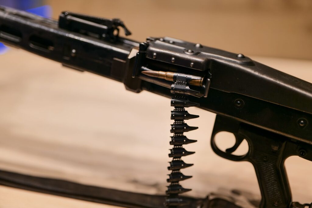 A detailed view of a rifle with ammunition belt, captured in Turanj, Croatia, highlighting military equipment.